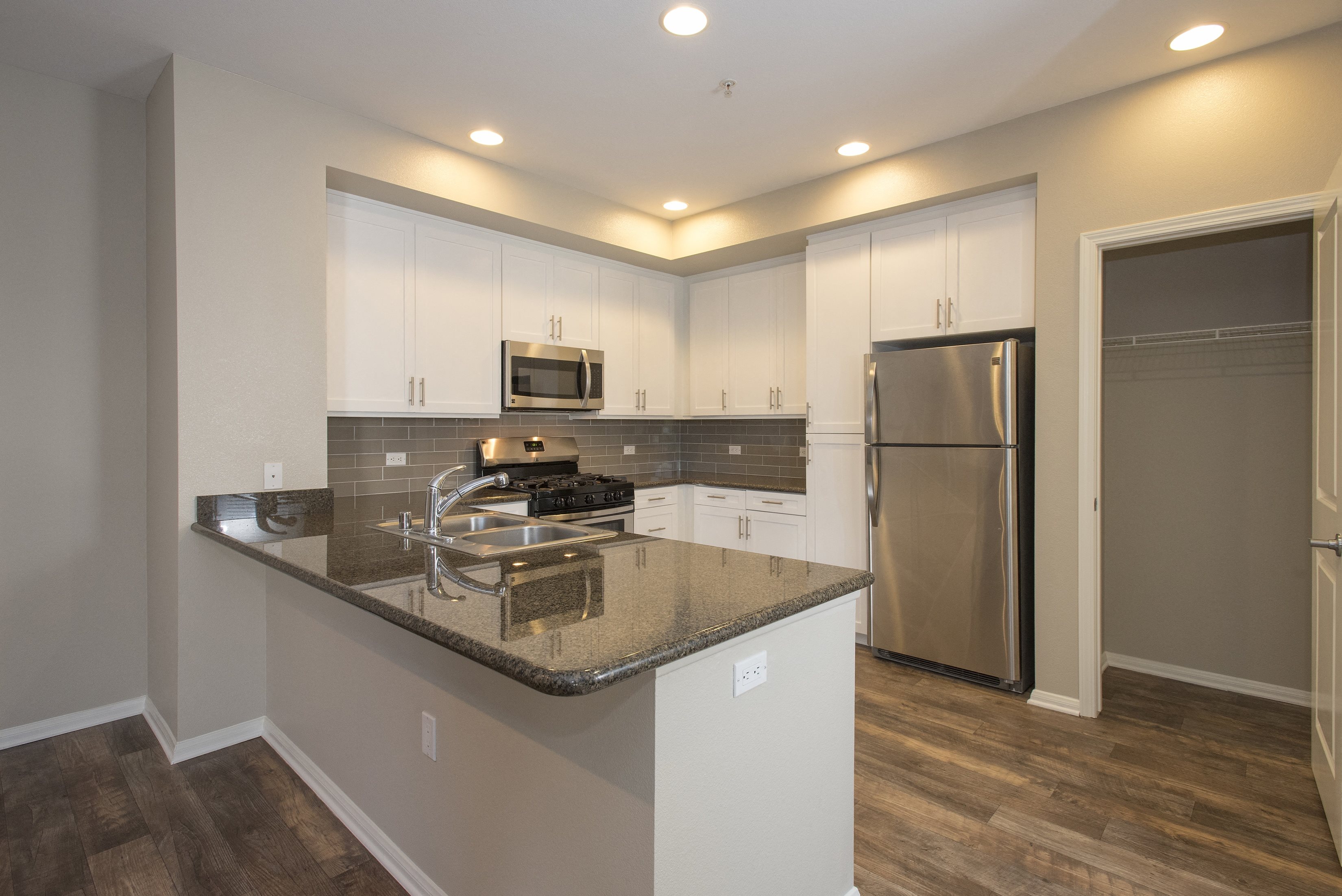 a kitchen with a granite counter top and a stainless steel refrigerator